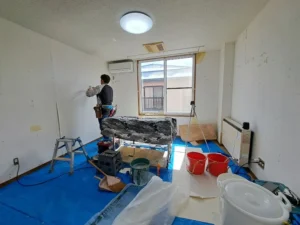 原状回復工事で壁紙を張り替える職人の作業風景