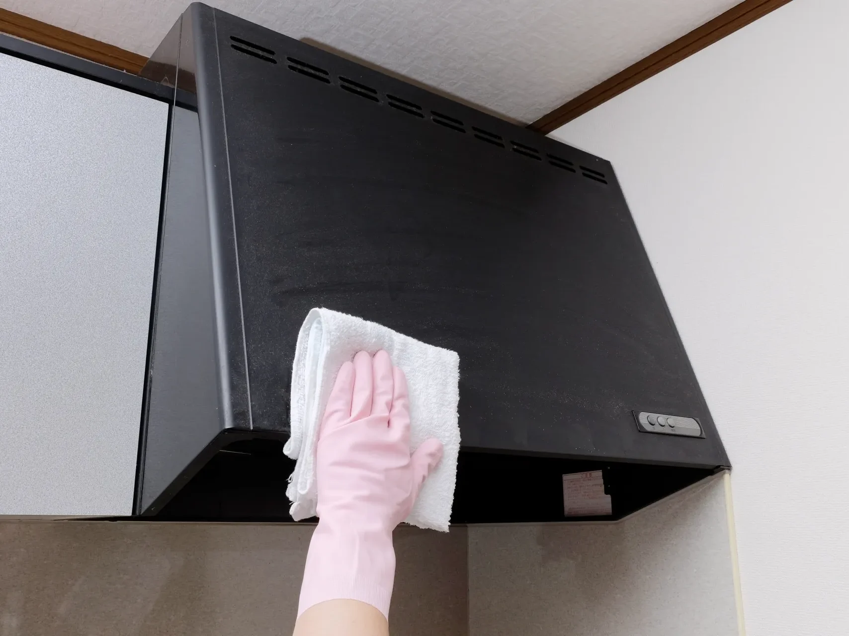 レンジフードを布で拭き掃除する様子