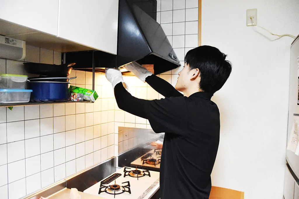 換気扇のフィルターをプロが分解清掃している作業風景