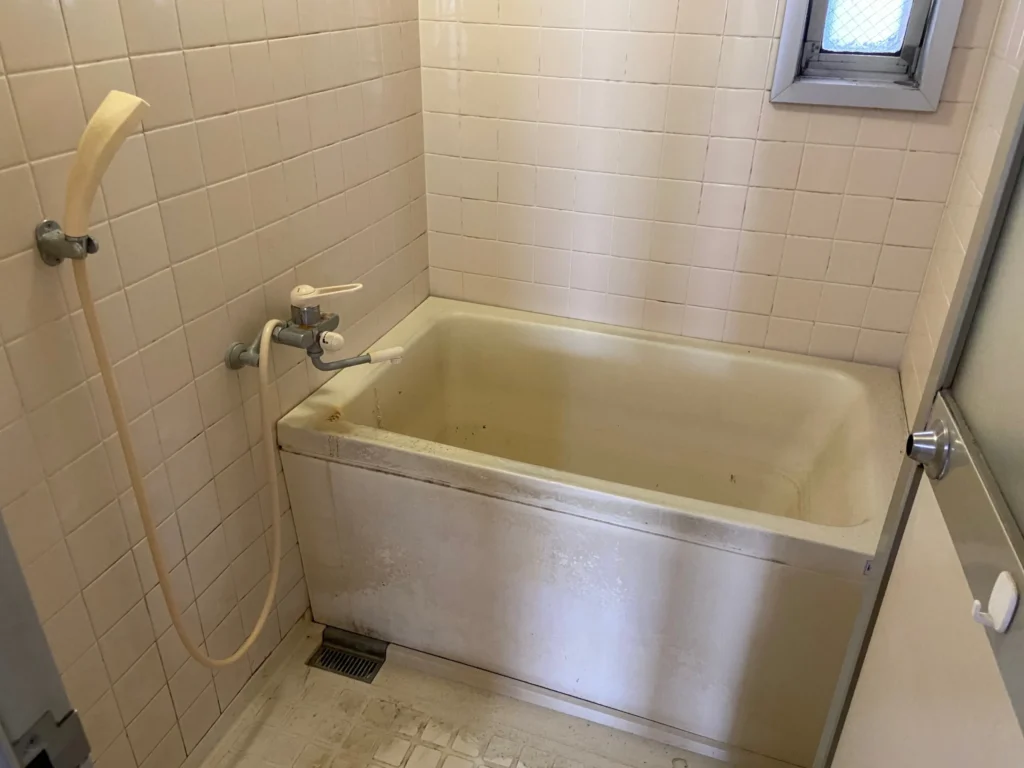 原状回復前の賃貸マンション浴室。経年劣化が見られるユニットバス