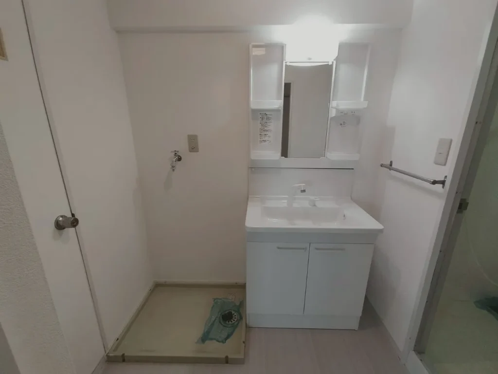 部分改修後の賃貸マンション洗面所。洗面化粧台と洗濯機置場が整った水回り空間