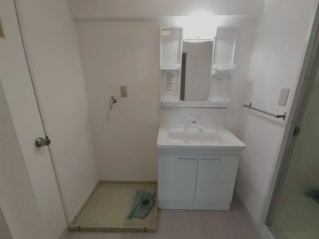 部分改修後の賃貸マンション洗面所。洗面化粧台と洗濯機置場が整った水回り空間