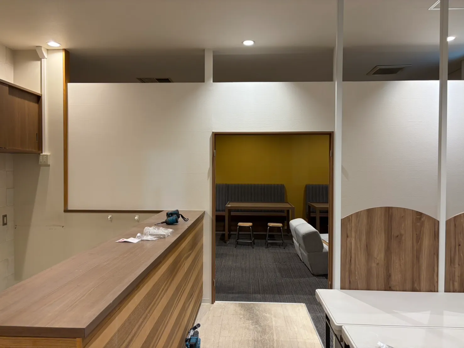 店舗内装リフォームの施工後写真。新設した木目調受付カウンターと待合スペースを備えた改修後の店内