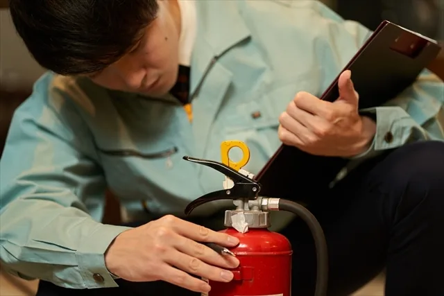 消火器を点検する作業員