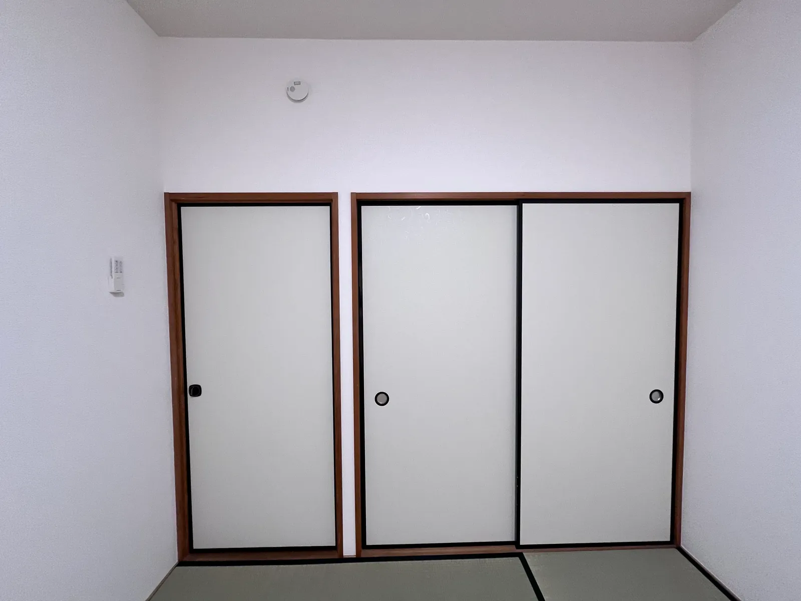 白い襖紙に貼り替えた和室の押入れの襖3枚。まわりの壁クロスも張替え済み